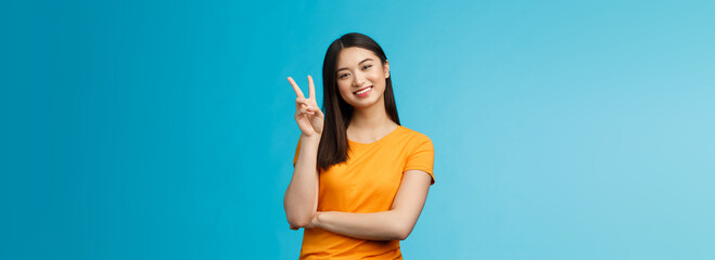 Optimistic cute tender asian young millennial girl send positive vibes, tilt head show peace,...
