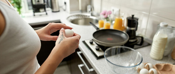 Cropped of girl holding egg near at kitchen