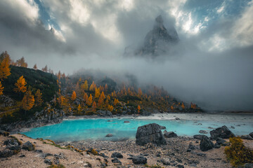 Amazing lake Sorapis and misty mountains at autumn, Dolomites, Italy
