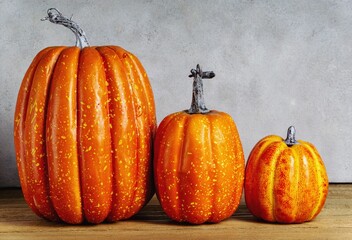 Three mock-up pumpkins on wooden table. Horizontal, moody Style. Halloween concept. Copy space.