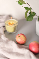 autumn aesthetic still life with apples and glowing candle. blog content. fall evening mood. selective focus, vertical