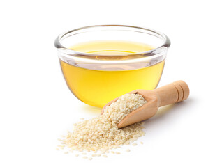 Sesame oil in glass bowl with white sesame in wooden scoop isolate on white background.
