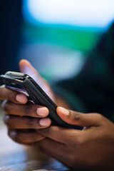 Hands of a black male using a cell phone with space for text