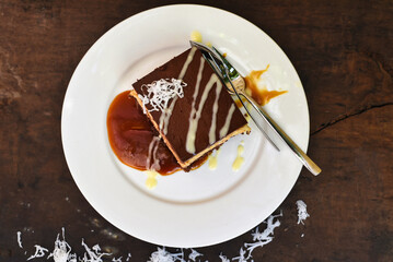 Coconut Cake on white plate with a spoon and caramel sauce