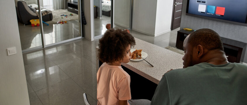 Back View Of Father And Son Having Lunch At Home