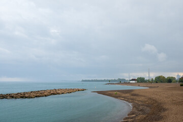 Rainy day on the beach:  view of breakwater, sand beach and a wooden lifeguard station.  Room for text.