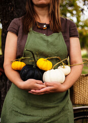 woman in linen wear holding a pumpkins.autumn background