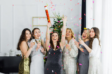 Happy party cracker with confetti and streamer of young women in celebrate New Year together at the...