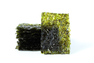 Seasoned seaweed snack. Algae sheets stacked in a pile on white background.