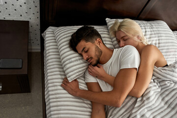 Top view of young multiracial couple sleep on bed