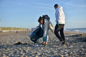 Volunteer man collecting trash on the beach. Ecology concept
