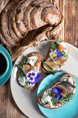delicious bruschetta with homemade bread, garnished with fig,soft cheese,pansies