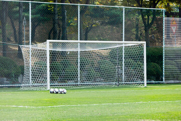 Soccer goalpost and soccer ball on soccer field.