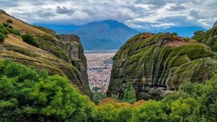 Fototapeta na wymiar Scenic aerial view of tourist village of Kalambaka, Thessaly, Greece, Europe, Pindus mountains. Dramatic rock complex of Meteora seen from Holy Trinity Monastery build on moss overgrown rock formation