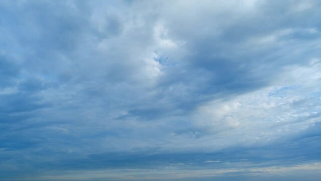 Light high clouds slide on sky. Layer of clouds in blue sky moving horizontal in opposite direction. Timelapse.