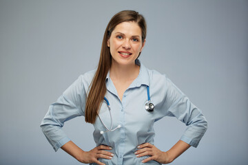 Smiling doctor woman in medical uniform holding hands on waist. Isolated portrait of female medical worker