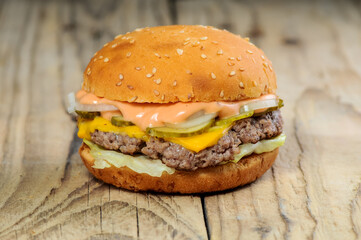 big cheeseburger with juicy cutlet on wooden background
