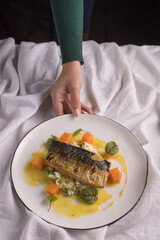 Grilled fish with garnish on light fabric background, modern restaurant concept