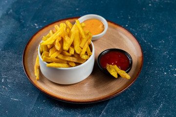 Crispy French Fries or potato chips with mayo dip and tomato sauce served in a plate side view view