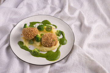 panko breaded meat with potatoes on a light fabric background