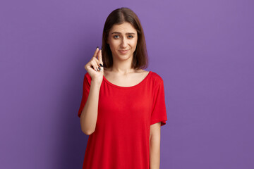 Some more, please. Doubting unsure young pretty brunette girl in red t-shirt shows small size...