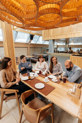 A group of friends is having pizza in a cozy restaurant. Meeting friends over dinner, socializing with a friendly company.