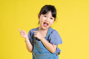 portrait of a beautiful asian girl, isolated on yellow background