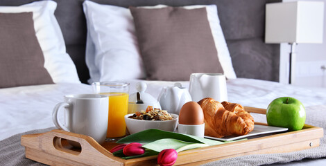 Breakfast on tray in bed in hotel room