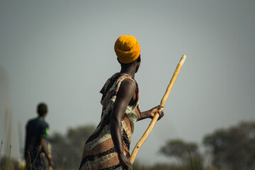 African woman on boat in okavango delta with stick guiding - obrazy, fototapety, plakaty