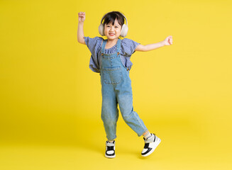 full body image of beautiful asian baby girl on yellow background