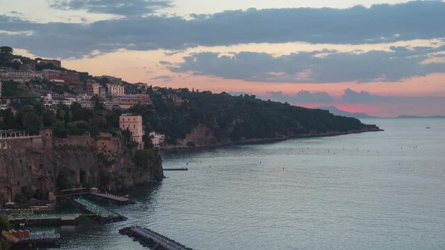 Sorrento, Italy. Time lapse video from sunset to night with sun going down and lights turning on, at the bay of Sorrento. In the distance the island of Capri. August 23, 2022.