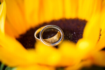 Fototapeta premium Wedding rings on the yellow bride bouquet.