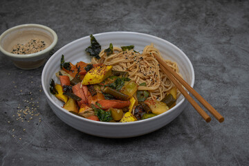 Vegan stir fry with noodles: carrot, squash and sea weed tubes