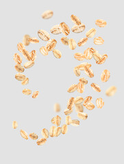 Flying raw oatmeal on light background