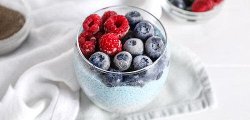 Glass of tasty chia pudding with berries on table, closeup