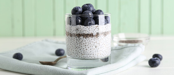 Glass of delicious chia pudding with blueberry on table, closeup