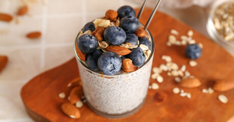 Glass of tasty chia pudding with berries and almonds on table, closeup