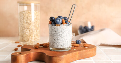 Glass of tasty chia pudding with berries and almonds on table