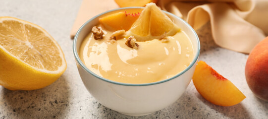 Bowl of delicious pudding with fruits on light background, closeup