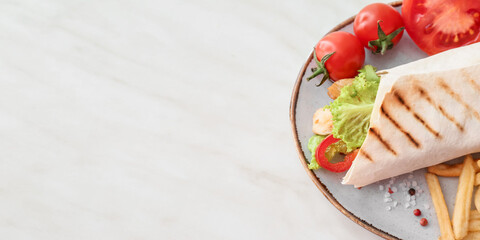 Plate with tasty doner kebab and vegetables on light background with space for text, top view