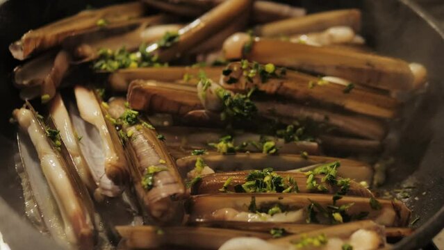 Razor clams seafood grilled on market, grill Spanish Navajas, traditional food in Spain, Catalonia, Barcelona.