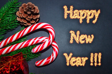 Happy New Year, Christmas candy on the branches of the Christmas tree sticking out of the cap of...