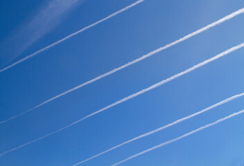 Five parallel condenstation trails, contrails or vapor trails in a blue sky