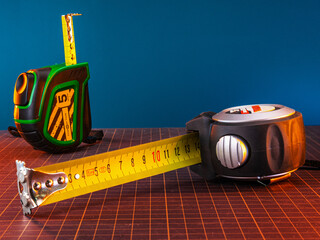 Construction tape measure on the table in the workshop. Analog measuring tool