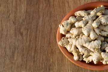 ginger on a clay plate on a wooden background