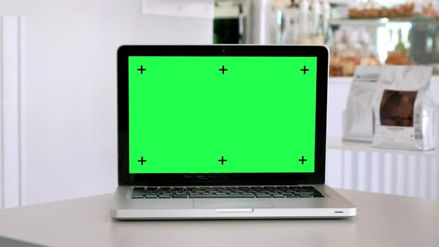 Chroma key green screen laptop computer set up for work on white desk, Home interior or office background, mock up, technology concept, zoom in.