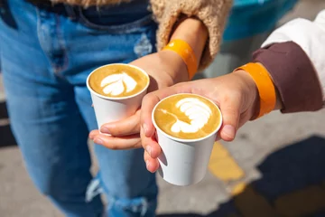 Papier Peint photo Lavable Café two woman holding coffee cup with latte art