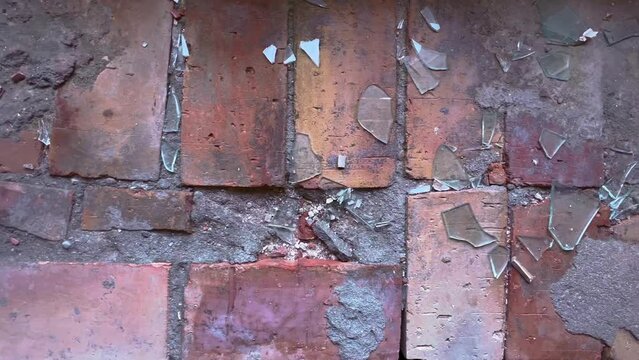 shattered glass pieces on brick floor, pan across.