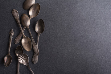 Set of vintage silver spoons on black background