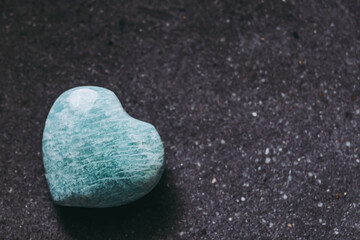 Obraz premium Pierre polie amazonite en forme de coeur sur un fond noir - Minéral naturel